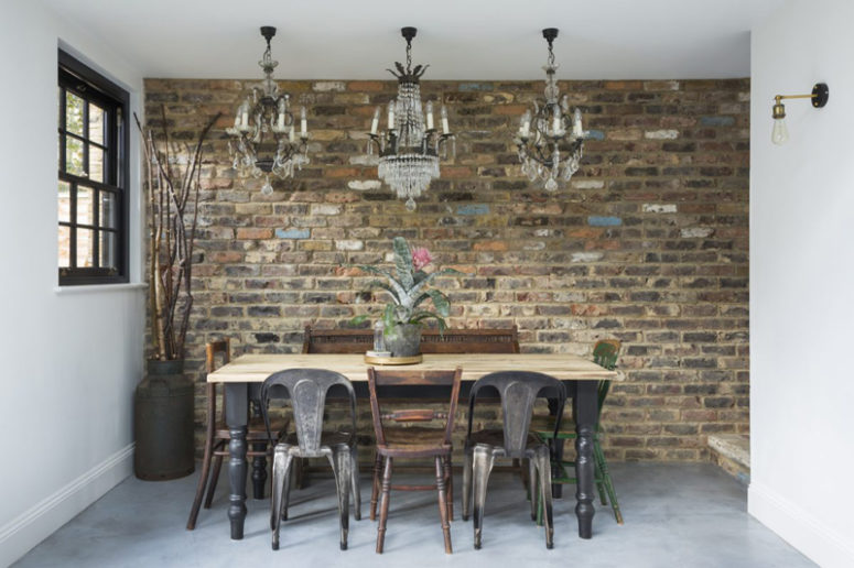 The dining space is vintage and industrial, with a rustic table, vintage chandeliers and industrial chairs