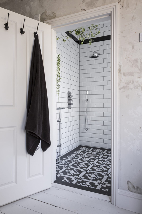 Black and white with fresh greenery make up the bathroom decor
