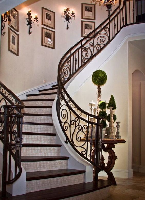 stunning indoor staircase of dark wood and custom-made wrought iron decor