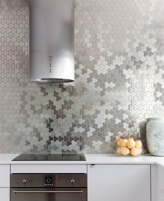 unique stainless steel puzzle wall covering instead of a kitchen backsplash