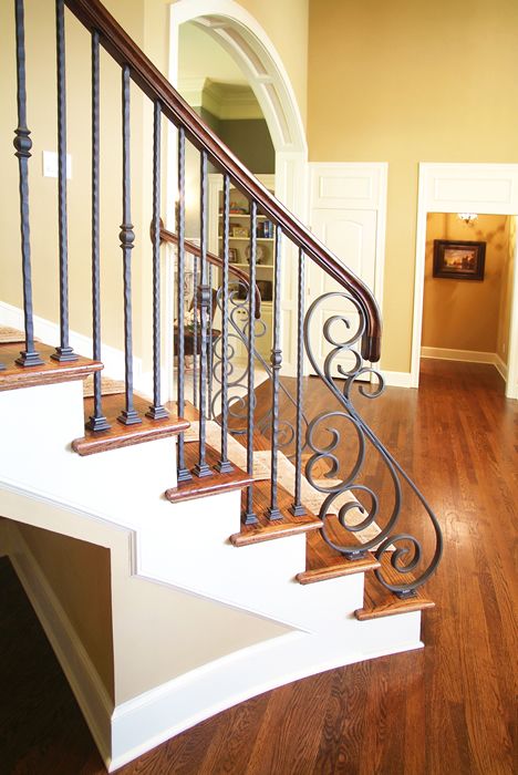 warm wood staircase and wrought iron balustrade of a lighter color to stand out