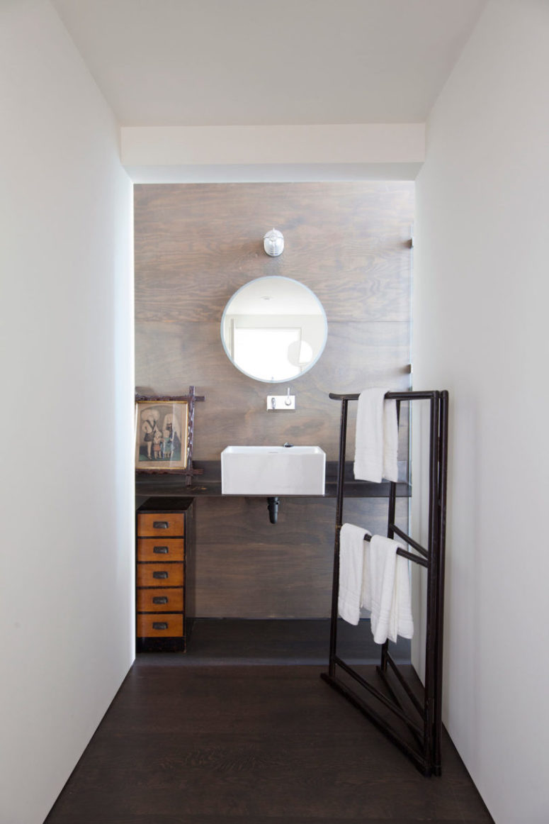 wood covered bathroom walls The bathroom is decorated with wooden panels, modern furniture and retro towel holders