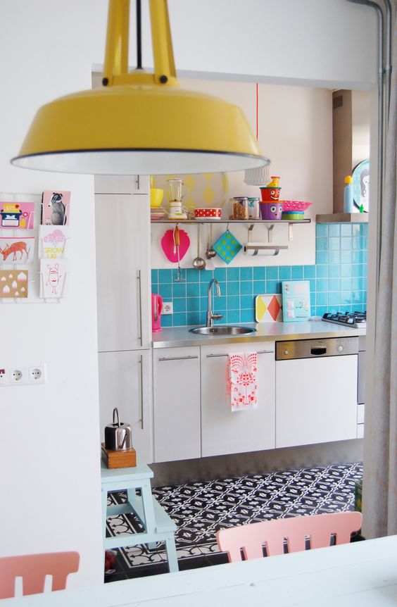 a bold light blue tile kitchen backspalsh and colorful dishes