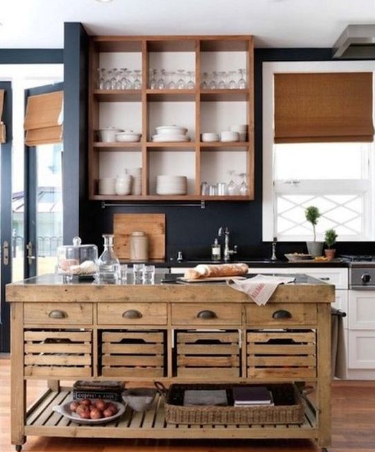 a wooden kitchen island with drawers and pallet boxes and open shelving