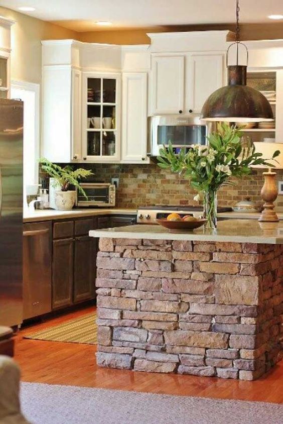 a brick clad kitchen island with a stone top looks textural
