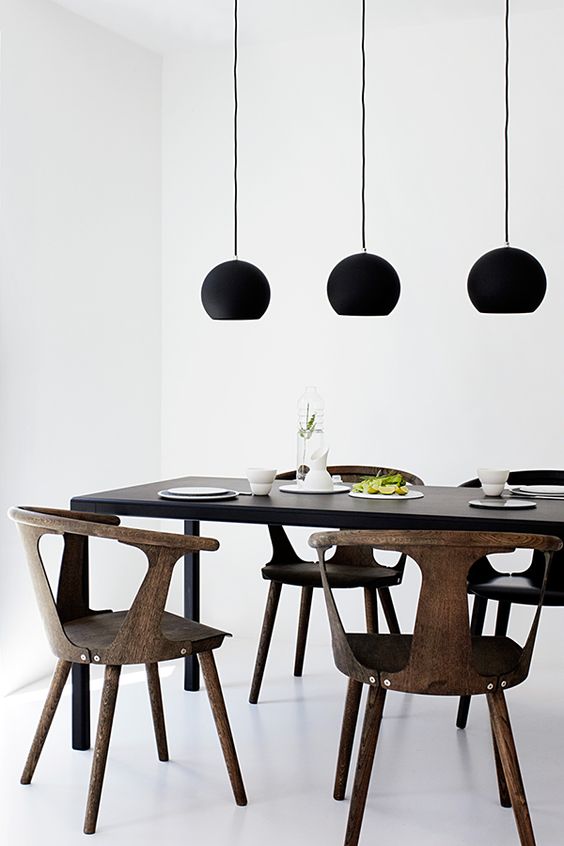 这个极简主义的用餐空间用无光泽的黑色吊灯加亮