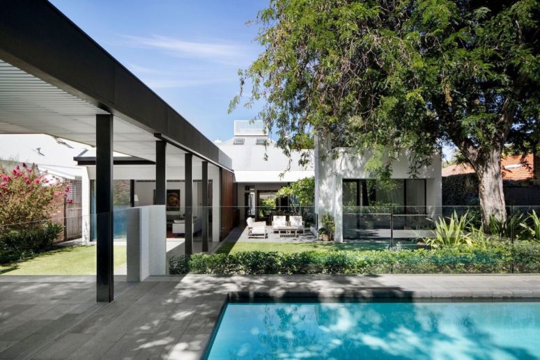 nice outdoor pool with a deck The interior spaces are connected to a garden and to a pool framed by a deck