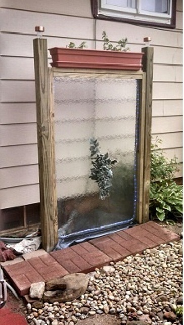 A practical DIY combination of a transparent water wall and a self-watering planter.