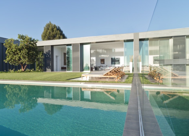 There's a large pool and a lounge area with a manicured lawn