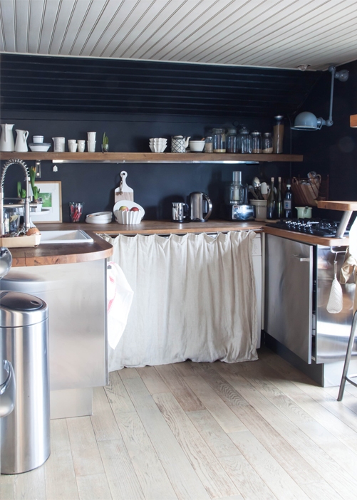 a black kitchen backsplash is practical and contrasts with light furniture