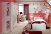 a lovely girl’s bedroom with pink and white furniture, a peachy accent wall and burgundy rugs and textiles plus lots of toys