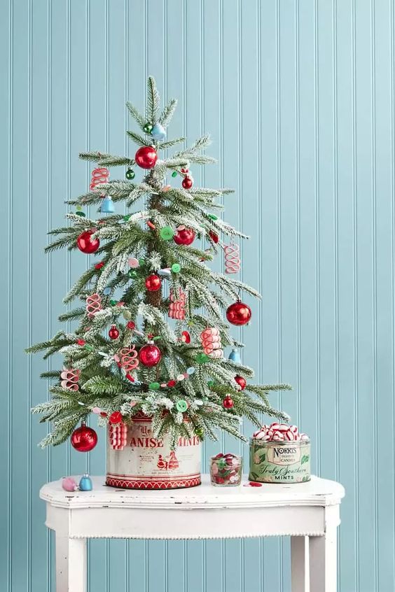 a retro-inspired tabletop Christmas tree with blue bells, red and green ornaments, buttons is a lovely idea for your space