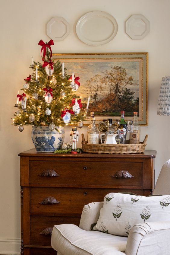 a tabletop Christmas tree decorated with silver and white ornaments, with embroidery hoop ones and red bows is a pretty idea