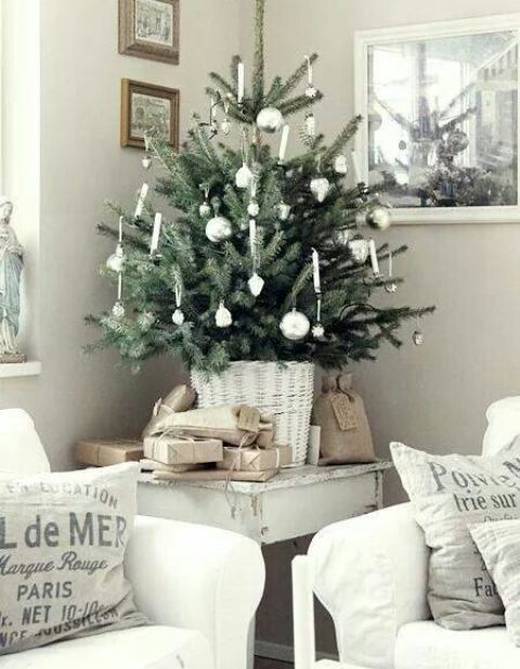 a tabletop Christmas tree in a whitewashed basket, with white and silver ornaments is a lovely idea for a Scandinavian space