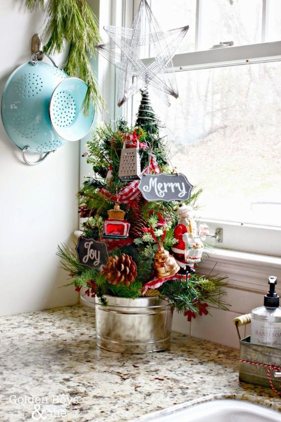 a tiny tabletop Christmas tree decorated with pinecones, berries, signs and kitchen stuff is a fun and cheerful idea to rock