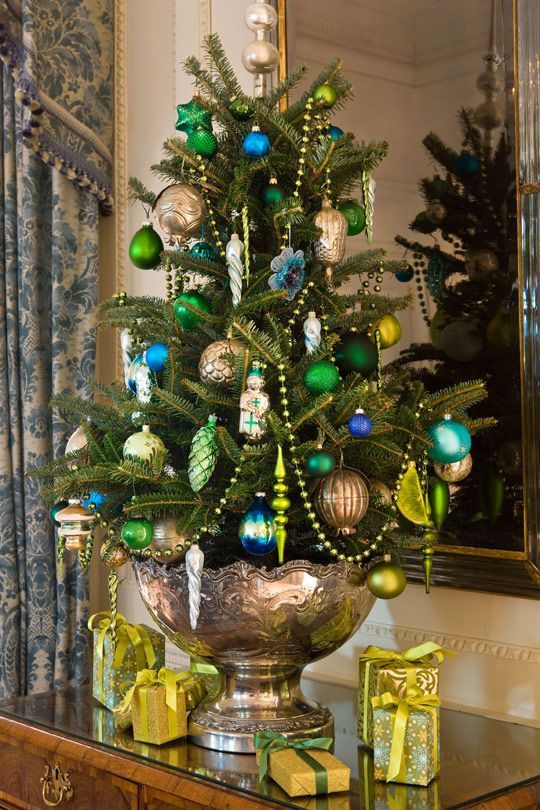 a vintage glam Christmas tree in a copper urn, with emerald, navy and gold ornaments, beads and colorful icicles is a cool idea