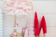 an arrangement of faux Christmas trees – bottlebrush ones and a porcelain one in pink and red for a girlish feel