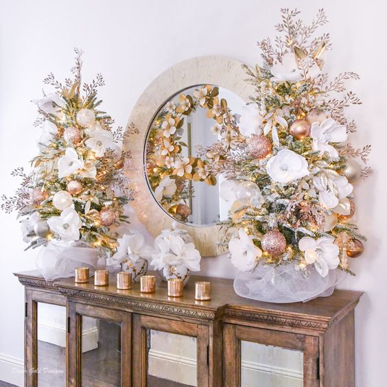 glam tabletop Christmas trees decorated with blush and pearl ornaments, with white fabric blooms and lights look very glam