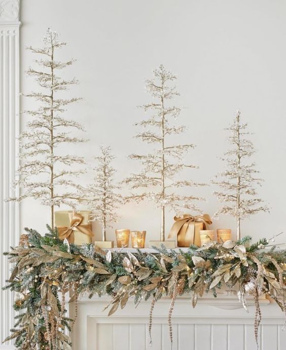 multiple faux Christmas trees, candleholders and an evergreen garland with magnolia leaves