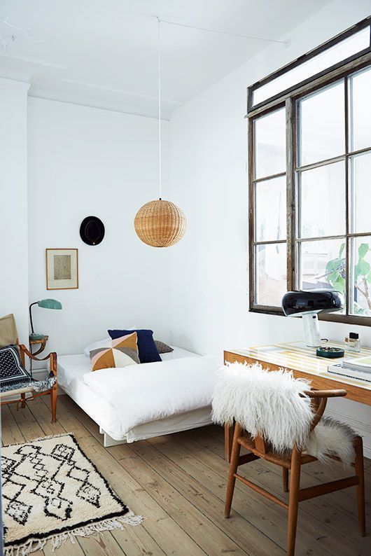 a teen Scandinavian room with a small bed, a desk and a chair, a rattan pendant lamp and a large window with no curtains