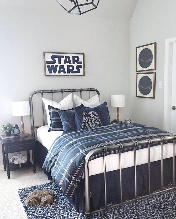 a Star Wars themed bedroom done in off-white and navy, with two tone bedding, signs, pillows and other small touches in decor