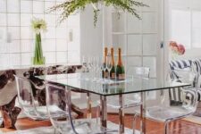 a dining table with metal legs and acrylic chairs on the same legs look modern, chic and ethereal