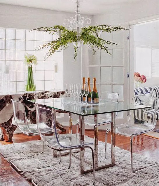 a dining table with metal legs and acrylic chairs on the same legs look modern, chic and ethereal