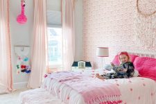 a fantastic pink boho girl’s bedroom with a pink wallpaper wall, light pink curtains, a bed with hot pink pillows and a hot pink rug
