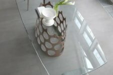 a glass dining table with a metal base with polka dots reminds of retro elegance and chic and brings an ultimate feel to the space