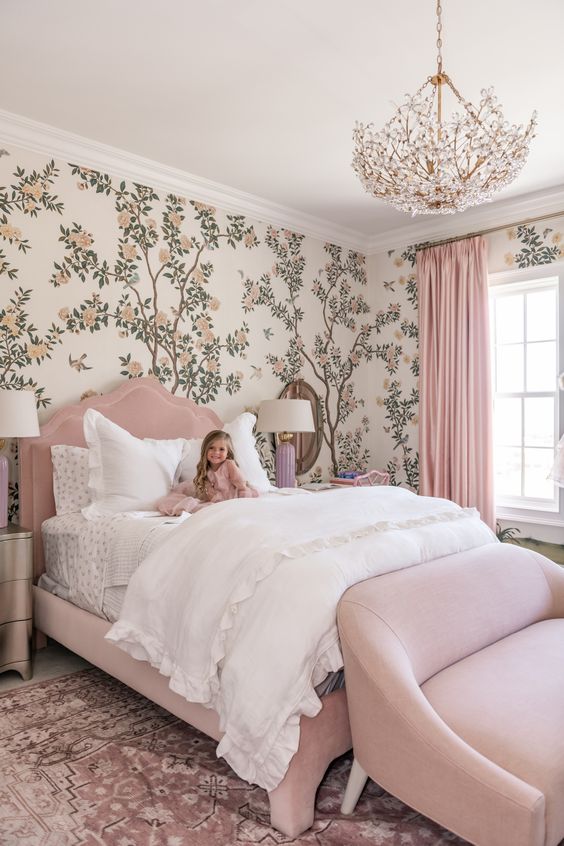 a kid's room with botanical wallpaper, a blush upholstered bed, a loveseat, a botanical chandelier and mirror nightstands