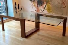 a modern sculptural dining table with a creative geo wooden frame and a large glass table top