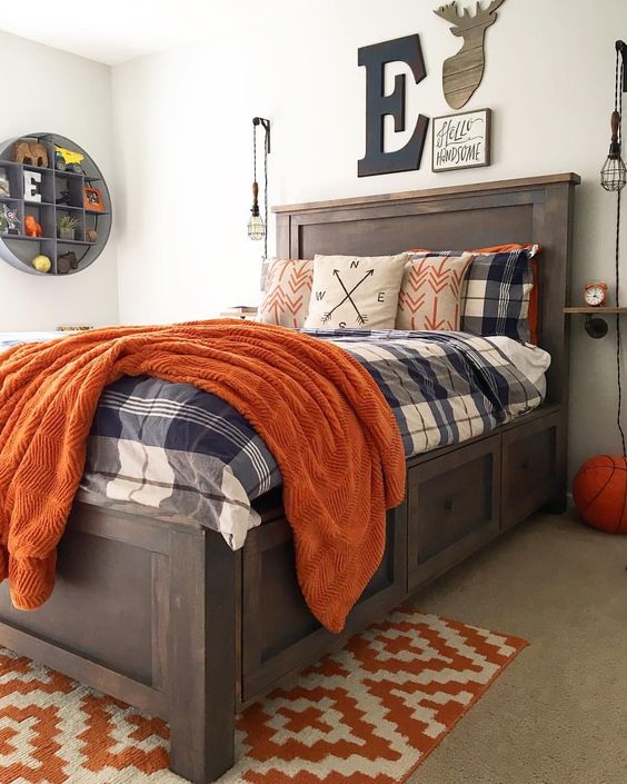 a rustic themed bedroom with a stained wooden bed, boho bedding, a gallery wall and an open round shelf