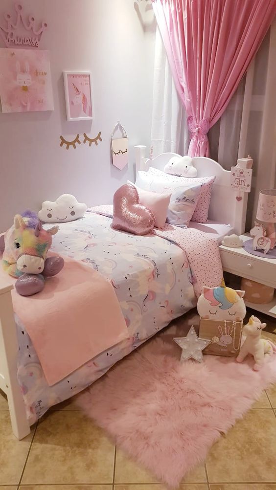 a small and lovely girl's bedroom with white vintage furniture, a pink curtain and bedding, a pink rug and lots of colorful toys