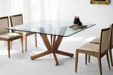 a square dining table with a glass tabletop and cool and stable wooden legs for a clean modern dining room