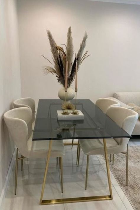 an ultra modern dining table with gold legs and a frame plus a smoked glass tabletop are a lovely and elegant combo for a modern space