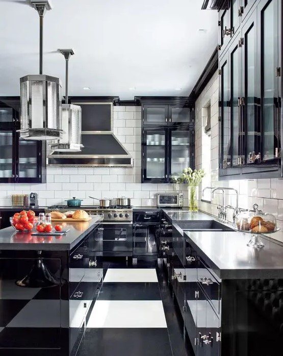 a bold art deco black and white kitchen with black cabinets with glass doors, a striped floor, glossy black cabinets and concrete countertops