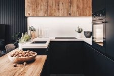 a stylish black kitchen with a wooden countertop