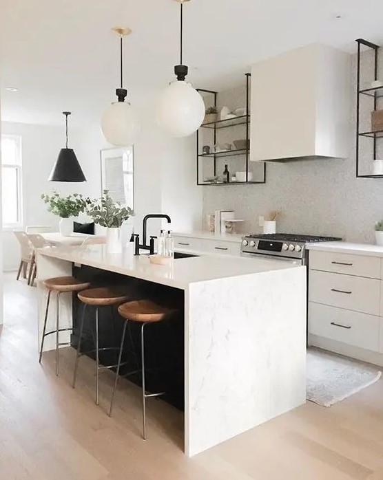 a chic contemporary kitchen with elegant white cabinets, a white tile backsplash, a black kitchen island with a white stone countertop and pendant lamps