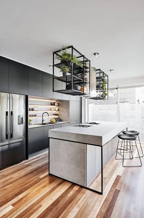 a contemporary kitchen with sleek black cabinets, a concrete kitchen island, black framing, black stools and built-in lights