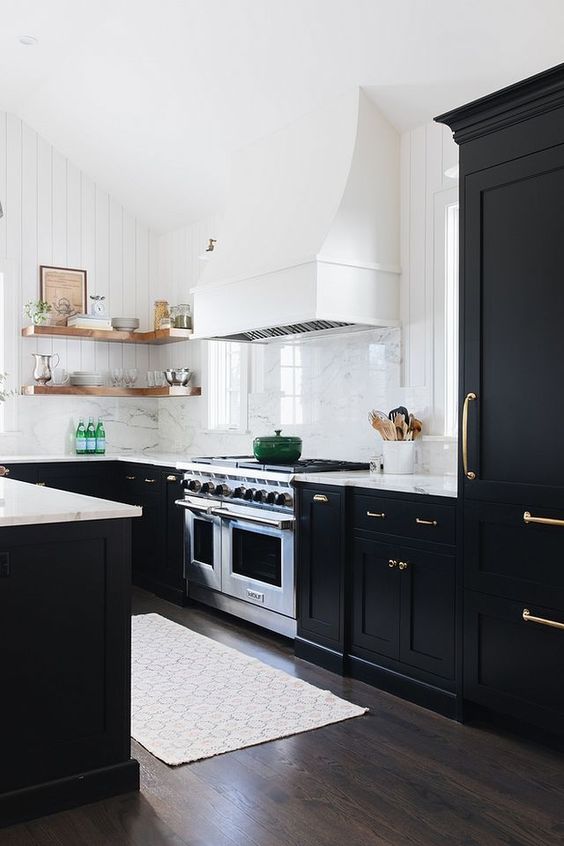 a modern farmhouse black and white kitchen with shaker cabinets, white marble countertops, open shelving, a white hood and a white marble backsplash