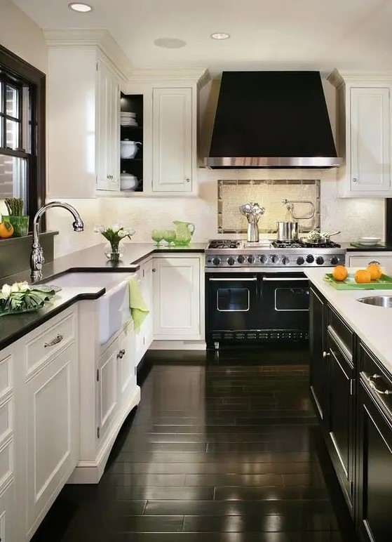 a refined retro kitchen with white shaker cabinets and a black shaker style kitchen island, a black floor and a black hood, shiny metals