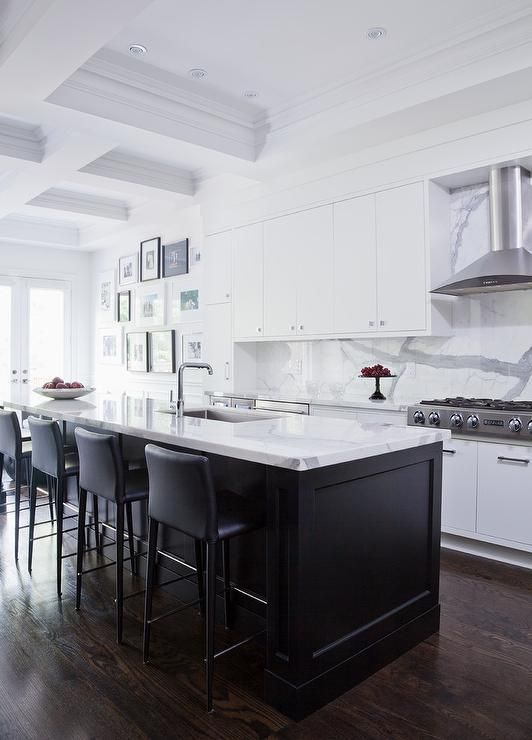 a stylish black and white kitchen with sleek cabinets, a black kitchen island with white marble countertops and a backsplash, black stools