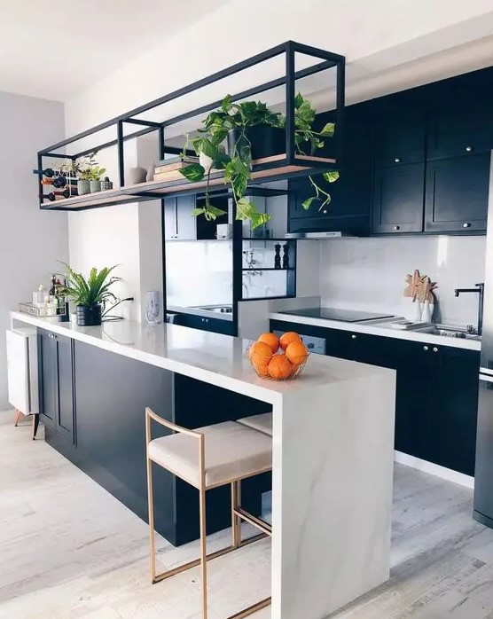 a stylish contemporary kitchen with black cabinetry, a large kitchen island with a waterfall countertop, a black metal shelf and black fixtures