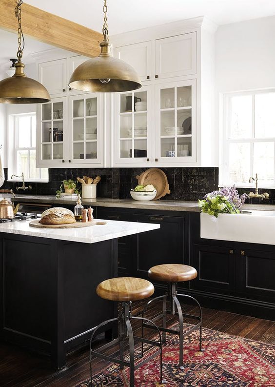 a vintage-inspired kitchen with black shaker cabinets, white countertops and a black Zellige tile backsplash, metal pendant lamps