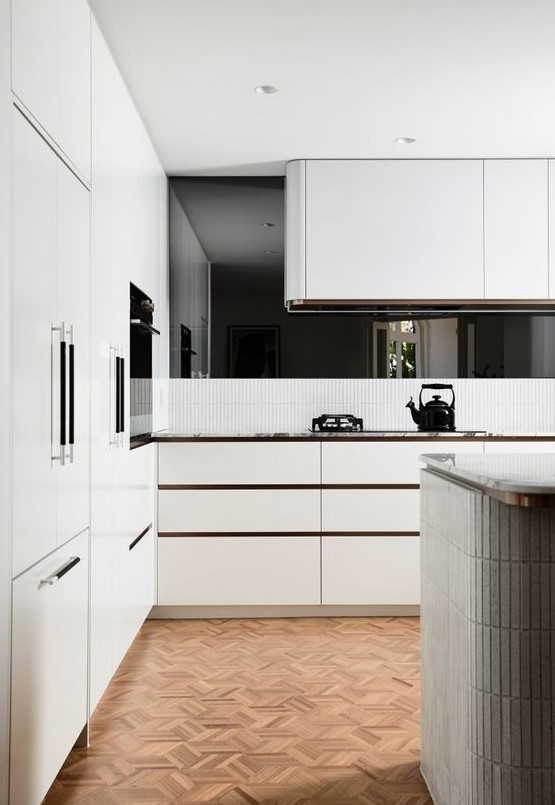 a white contemporary kitchen with sleek cabinets and a curved hood over the cooker is a stylish idea