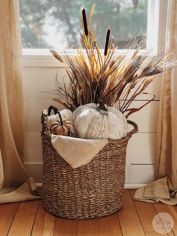 a Thanksgiving arrangement in a basket - faux pumpkins and wheat plus some burlap is great for fall, too
