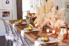 a chic modern Thanksgiving table with candles, pampas grass, pears, copper jars, cutlery and printed plates