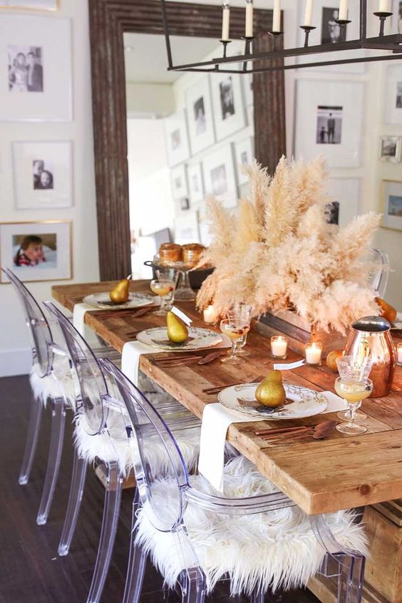 a chic modern Thanksgiving table with candles, pampas grass, pears, copper jars, cutlery and printed plates