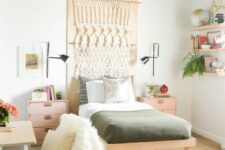 a boho teen room with a green ceiling, a macrame hanging, floating shelves, pink nightstands and a tiny desk and a chair