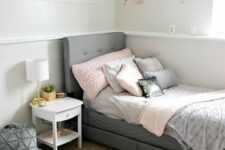 a contemporary teen room with a grey upholstered bed, layered rugs, soft pillows and a gallery wall